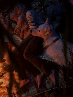 an animated image of two people and a dog sitting on the ground in front of a fire