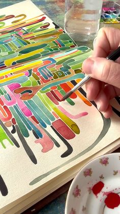 a person is painting on paper with watercolors