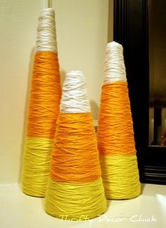 three orange and white yarn cones sitting on top of a counter next to a mirror