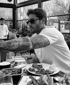 a man sitting at a table with food in front of him