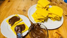 two plates with pieces of yellow cake on them and chocolate frosting in the middle