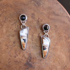 This one-of-a-kind pair of Rose Cut Faceted Black Agate and Scenic Dendritic Agate drop Earrings will knock your socks off! The Earthy toned, natural, Dendritic Agate hangs below the faceted black agate posts with three sterling Silver Rings. All Metal is .925 Sterling Silver. The stunning pair of bottom stones are gently colored with warm hues of amber and brown to black and contrast boldly with the faceted black agate top posts. Truly a pair of statement earrings that respect the nature from where they came in their simplicity and elegance. All .925 Sterling Silver.  Top stones - Black Agate - 8mm Bottom - Palm Root Fossil 9x24mm Total length 1 3/4 in All metal is .925 Sterling Silver These post earrings will come with Standard Titanium Clutches no droop Clutches. All traditional silvers Luxury Agate Earrings With Natural Stones, Unique Polished Drop Earrings, Artisan Polished Earrings For Gift, Polished Onyx Earrings For Gift, Metal Smithing, Silver Statement Earrings, Carnelian Ring, Dendritic Agate, Boho Pendant