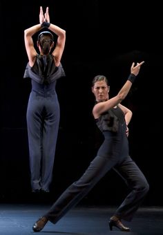 two dancers performing on stage with one holding his head in the air and another standing behind him