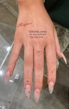 a woman's hand with some tattoos on it