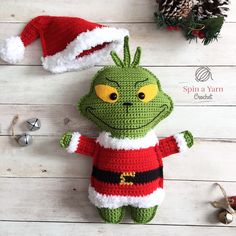 a crocheted grin face doll with santa's hat on top of it