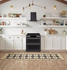 a kitchen with white cabinets and an oven in the center, along with open shelving