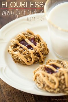 cookies with peanut butter and jelly are on a plate next to a glass of milk