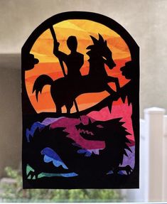 a stained glass window with a silhouette of a man riding a horse