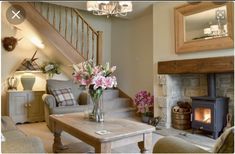 a living room filled with furniture and a fire place in front of a stair case