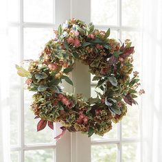 a wreath hanging on the side of a window