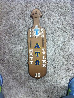 a person standing in front of a carpeted floor next to a plaque with letters and numbers on it