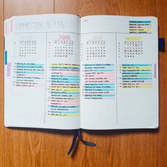 an open planner book sitting on top of a wooden table