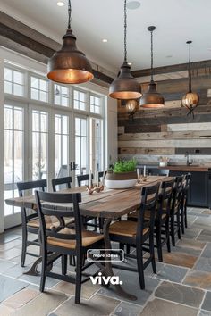 a dining room table and chairs with lights hanging from the ceiling