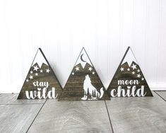 three wooden signs with the words stay wild, be a child and a dog on them