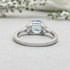 This beautiful ring is made from genuine 925 sterling silver with rhodium plating. Ring details- -The Main stone is a Cushion Cut 7MM Natural Aquamarine Stone -Side stones are 1mm Round simulated diamonds -Ring is casted in solid 925 sterling silver with rhodium plating (yellow gold and rose gold plated also available, please check the drop down menu for more options) -The Total face height of the ring measures 7.5mms and the band width measures 2mms -Each ring is handmade and made to order, so Silver Ring With Polished Blue Topaz, Silver Rings With Polished Blue Topaz, Silver Rings With Blue Topaz And Polished Finish, Silver Blue Topaz Ring With Polished Finish, White Gold Blue Topaz Cushion Cut Ring, White Gold Princess Cut Gemstone Ring, Silver Sapphire Promise Ring In 14k White Gold, Silver Sapphire Princess Cut Ring For Promise, White Gold Sterling Silver Topaz Promise Ring