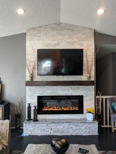 a living room with a fireplace and flat screen tv on the mantel above it