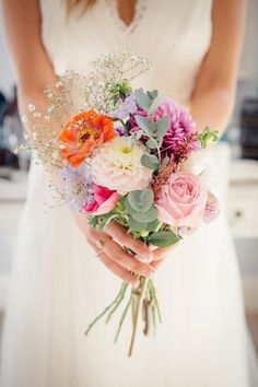 a woman holding a bouquet of flowers in her hands