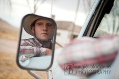 a man wearing a hat looking out the window of a car