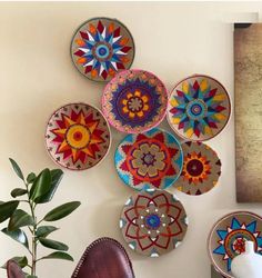 colorful plates are hanging on the wall next to a potted plant