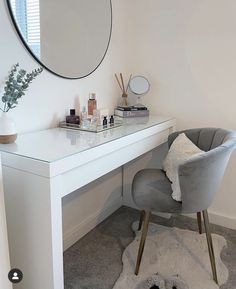 a white desk with a mirror, chair and other items on it in a room