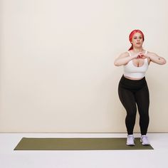 a woman with red hair is standing on a yoga mat