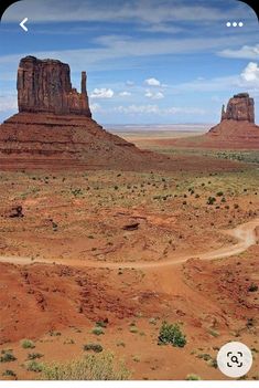 an image of a dirt road in the middle of desert with rocks and mountains behind it