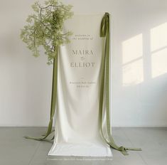 a white chair with a green ribbon tied around it and a bouquet of flowers on the back