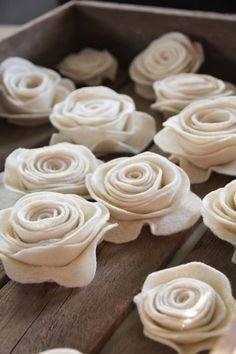 some white flowers are sitting in a wooden box on a table and ready to be made into something else