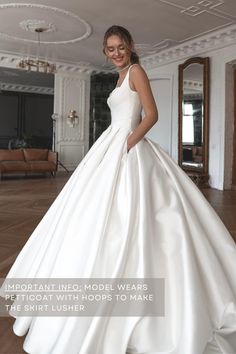 a woman in a white wedding dress posing for the camera with her hands on her hips