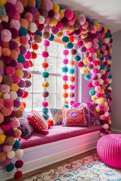 a window seat with colorful pom - poms hanging from it's sides