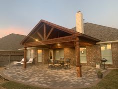 a covered patio with table and chairs in the evening