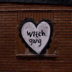 a heart painted on the side of a brick building with words written in black and white