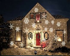 a house with snowflakes all over the front and side of it at night