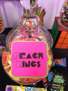 a candy jar filled with peach rings on top of a table