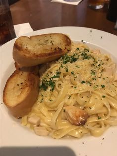 a white plate topped with pasta and garlic bread