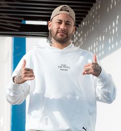 a man in a white hoodie is giving the thumbs up