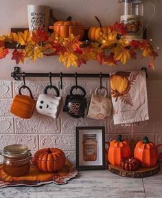 the kitchen counter is decorated with pumpkins and other autumn decorations, including mugs