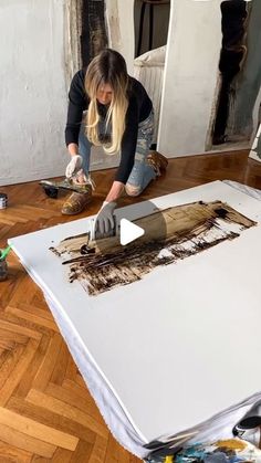 a woman in black shirt painting on canvas