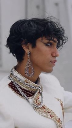 a close up of a person wearing some kind of necklace and earring on their head