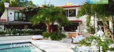 a house with a swimming pool surrounded by palm trees