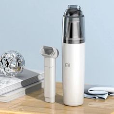 an electric toothbrush is sitting on a table next to a white and silver bottle