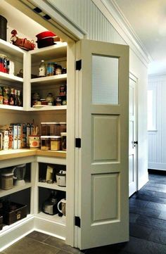 an open pantry door in the middle of a kitchen with lots of food on shelves