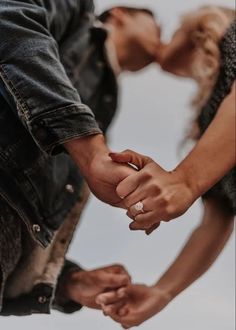 two people holding hands while standing next to each other