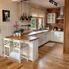 a kitchen with wooden floors and white cabinets