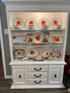 a china cabinet with plates and bowls on it