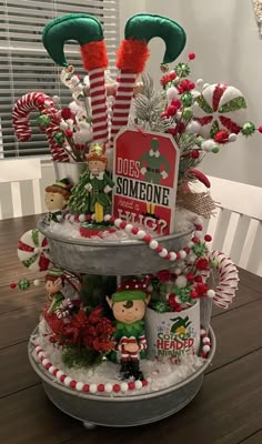 a three tiered christmas tree decorated with candy canes, ornaments and other holiday decorations