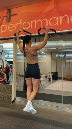 a woman is doing exercises in front of a mirror with her hands on the bars