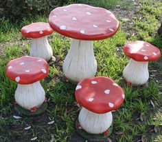 a group of red and white mushrooms sitting in the grass