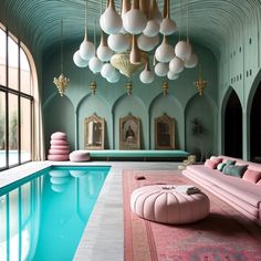 an indoor swimming pool with pink couches and chandeliers hanging from the ceiling