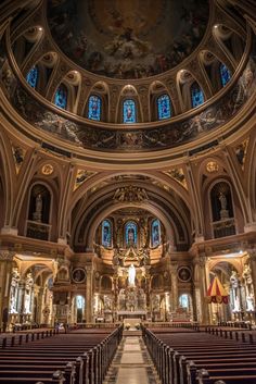 the inside of a church with pews and stained glass windows on the ceiling,